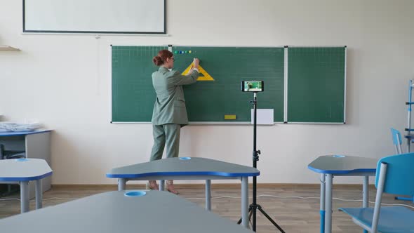 Teacher Near Blackboard Using Mobile Phone Video Camera Recording Herself on Learning Online Math