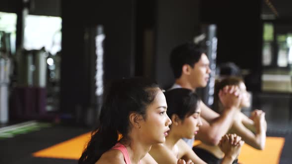Group of Athletic Young Asian People in Sportswear Doing Squat and Exercising at the Gym