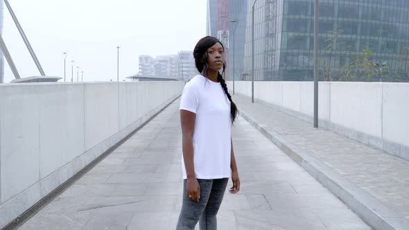 Sporty young woman standing on a bridge