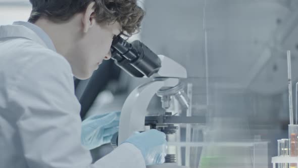 Biotechnology Scientist Looking into Microscope alt