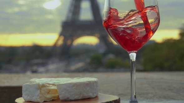 Red Wine Is Poured Into Glass Against Eiffel Tower