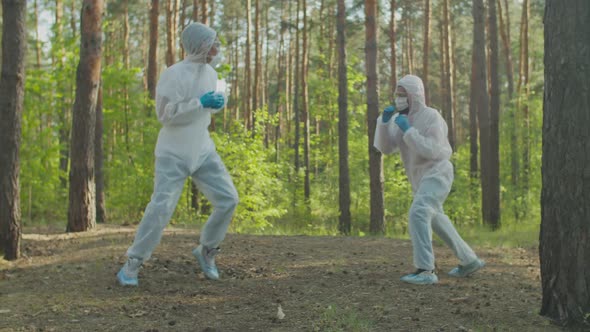 Men in Protective Suits Boxing in Nature