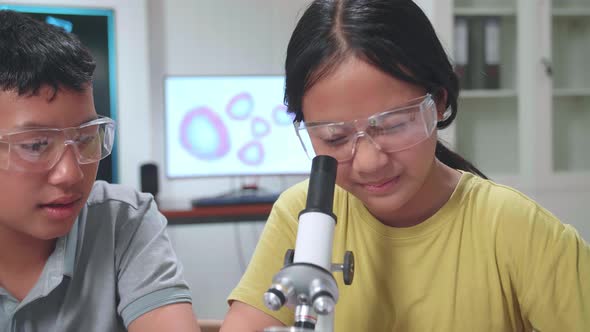 Young Asian Boy And Girl Learning Science Experiment. Study With Scientific Equipment