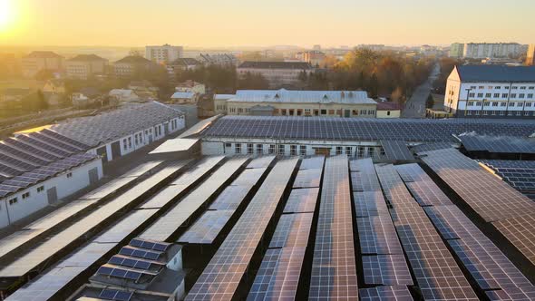 Aerial View of Solar Power Plant with Blue Photovoltaic Panels Mounted on Industrial Building Roof