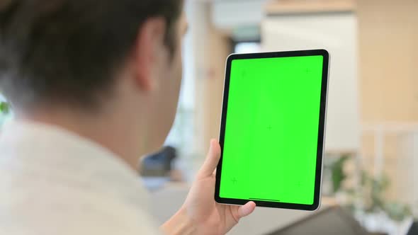 Young Man Using Tablet with Green Chroma Screen