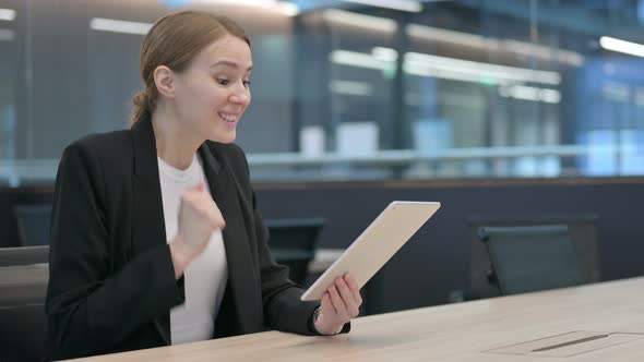 Successful Businesswoman Celebrating on Tablet at Work