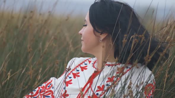 Portrait of Cheerful Charming Young Ukrainian Woman in National Clothes in Field