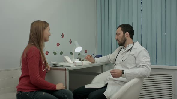 Male Doctor in Clinic Giving Reccomendation To Patient About Pills