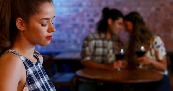 Jealous woman looking at couple flirting with each other