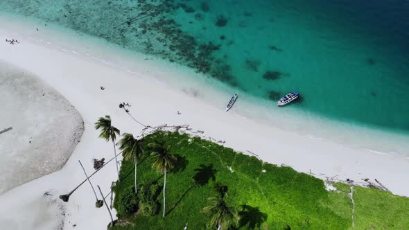 Cinematic overhead aerial view of a beautiful small island beach in the middle of the ocean