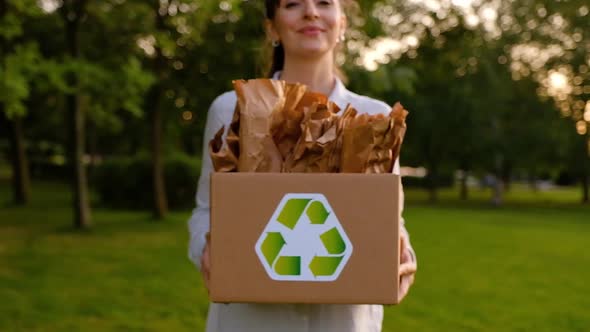 Beautiful young woman holding a box with paper bags