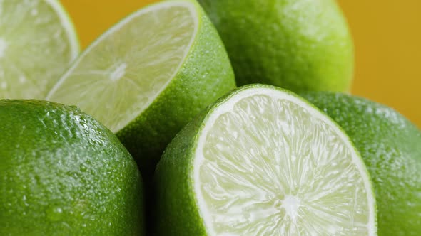 Green Limes Isolated on Yellow Background Fresh and Ripe Citrus Fruits