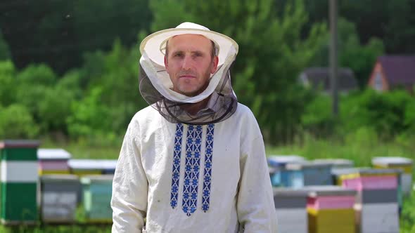 Beekeeper in protective workwear. Portrait of happy male beekeeper at apiary