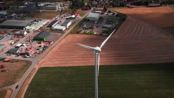 Windmill with rotating blades in field. Wind turbine with working propellers at countryside