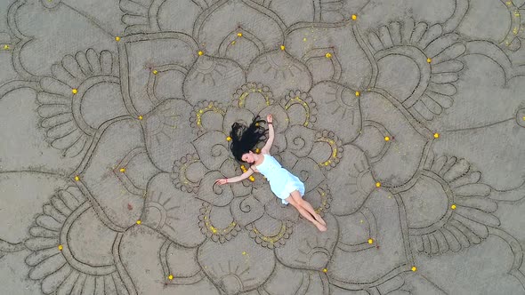Woman Drawing the Big Mandala at Sand and Dancing in Empty Beach Top View Above From Drone
