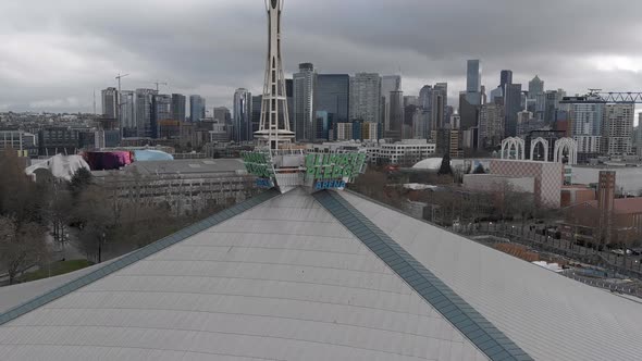 Wide establishing aerial of Climate Pledge Arena with the Space Needle in the background.