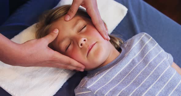 Physiotherapist giving head massage to a boy 4k