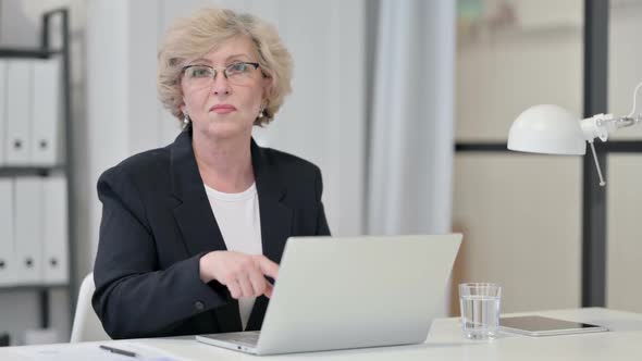 Old Businesswoman with Laptop Showing No Sign By Finger