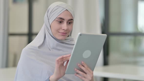 Young Arab Woman Celebrating Success on Tablet