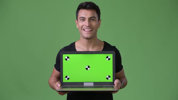 Young Handsome Hispanic Man Against Green Background