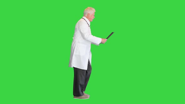 Doctor in a Rush Viewing MRI Scans While Walking on a Green Screen Chroma Key