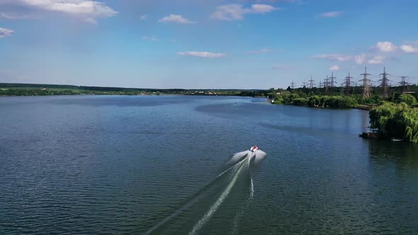 Driving speed boat on river. Aerial view over the floating boat