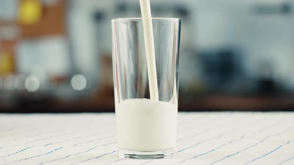 Yogurt are Pouring Into a Glass Cup From Bottle