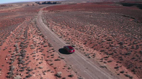 Red car driving the desert