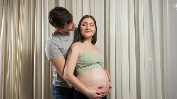 Married Couple Hugs Caressing Pregnant Bare Belly with Love