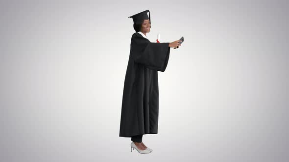 Happy African American Female Graduate Holding Diploma and Making Selfie on Gradient Background