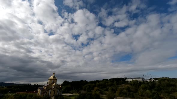 Time lapse: the sun hidden behind fluffy clouds flying in the sky.