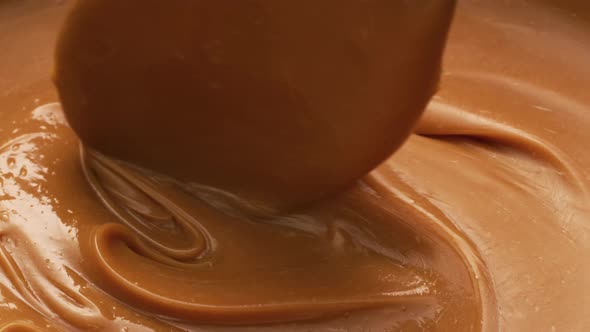 Stirring melted caramel, closeup food shot. 