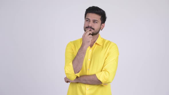 Young Happy Bearded Indian Businessman Thinking While Looking Up