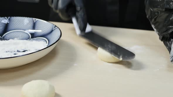 the Hands of a Pastry Chef in Black Gloves Prepare a Round Cheesecake