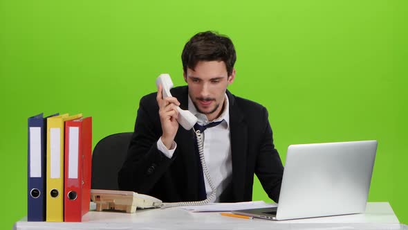 Man with a Headache Takes Telephone Receiver. Green Screen Studio