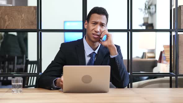 Phone Negotiation, Black Businessman Working on Laptop