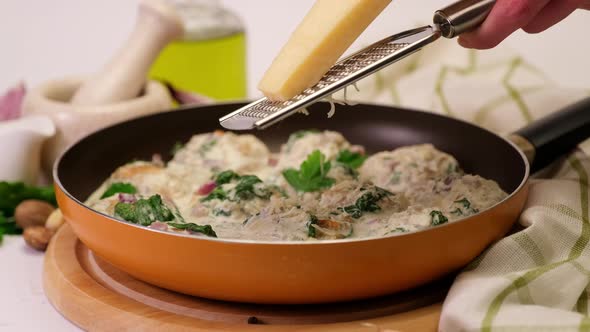 Delicious Small Meatballs with Spinach in a Creamy Sauce in the Frying Pan
