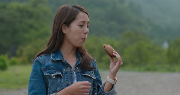 Woman having dorayaki with green background