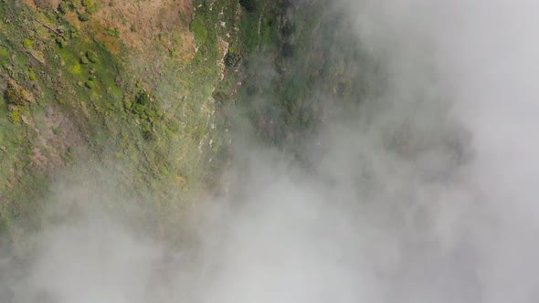 Aerial View of Mountain Slopes at Cloud Level Covered with Green Vegetation