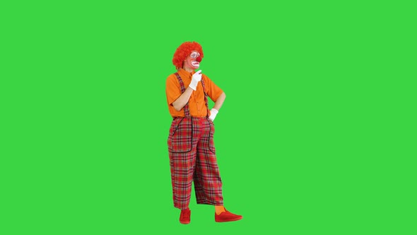 Clown Manipulating Virtual Objects in a Funny Way on a Green Screen Chroma Key