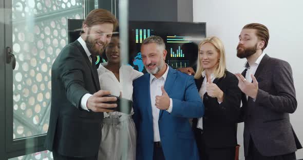 Professional Multiracial Businesspeople Taking a Selfie in Modern Meeting Room