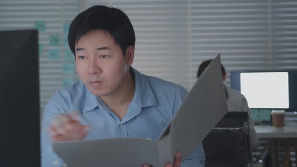 Concentrated Businessman looking at paperwork checking and reviewing a business financial report