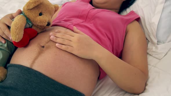 Happy Pregnant Woman Sleeping on Bed in Bedroom