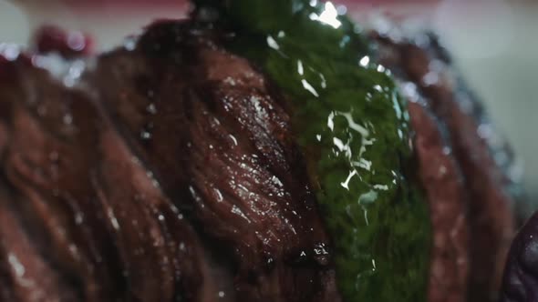 Close-up of Juicy beef steak filet mignon on plate is poured green herb sauce