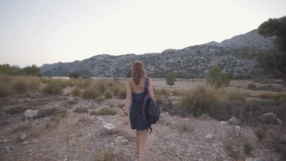 Beautiful Redhaired Woman Traveler Walks and Has a Good Time on the Rocky Island of Mallorca