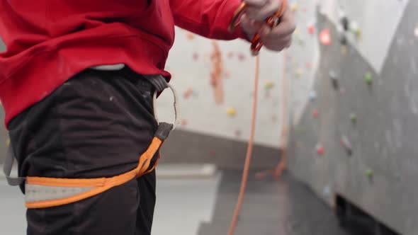 Sportsman Making Preparations before Climbing