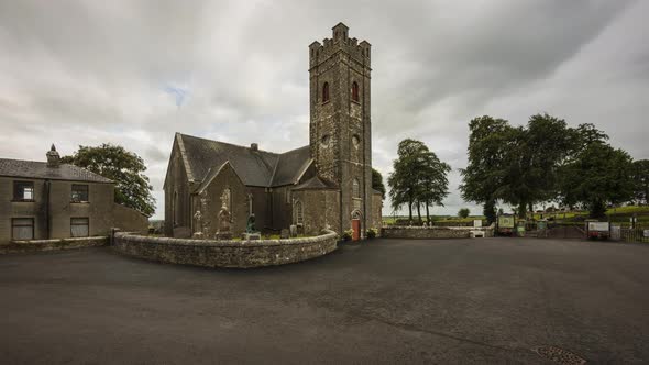 Time lapse of historical cemetery and medieval church in rural Ireland with passing clouds and sunsh