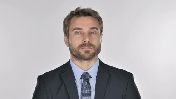 Serious Businessman Looking at Camera in Studio on White Background