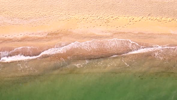 Aerial view of sand beach. Top view sea waves. Drone footage