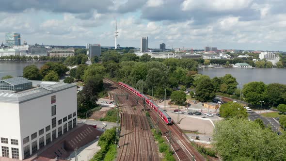 Aerial View of Train Unit Driving on Multitrack Railway Line Leading Through City